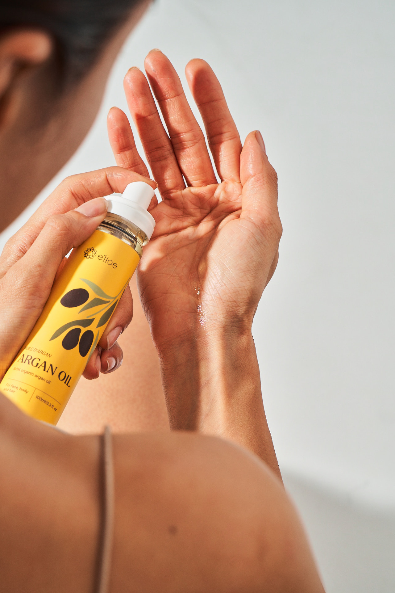 Argan oil being dispensed into an open palm
